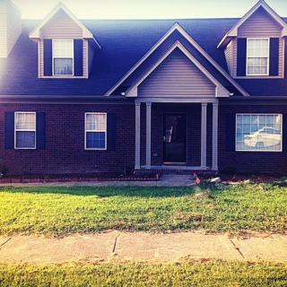 A charming brick house with a well-maintained front yard.
