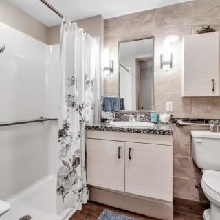 A modern bathroom with a floral shower curtain and sleek fixtures.