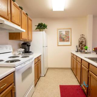 A clean and organized kitchen with wooden cabinets and modern appliances.