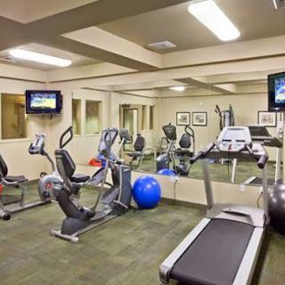 A well-equipped gym featuring various exercise machines and a comfortable environment for workouts.