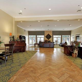 A spacious hotel lobby with a reception desk and seating area.