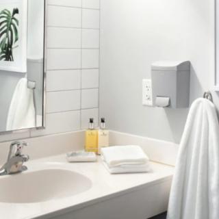A clean and modern bathroom sink with towels, soap, and a mirror.