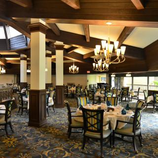 An elegantly designed dining room with chandeliers and neatly arranged tables.
