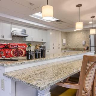 Modern kitchen with granite countertops and elegant lighting.