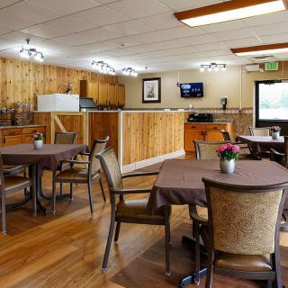 A cozy dining area with wooden paneling and neatly arranged tables and chairs.