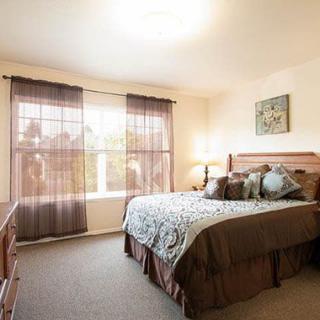 A cozy bedroom with a large bed, soft lighting, and elegant decor.