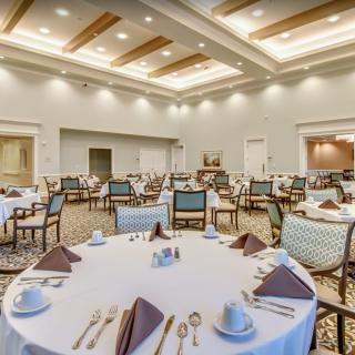 An elegant banquet hall set up with round tables and white tablecloths for a formal event.