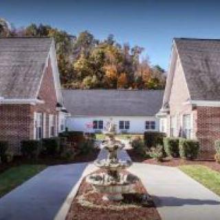 A symmetrical view of two brick buildings with a landscaped pathway in between.