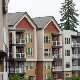A modern apartment building with multiple balconies and varied exterior colors.