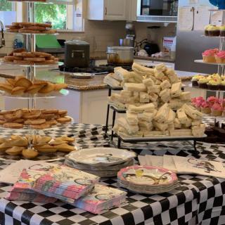 A kitchen setting with a table full of party snacks and desserts for a birthday celebration.