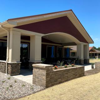 A modern architectural design featuring a spacious entrance and landscaped surroundings.