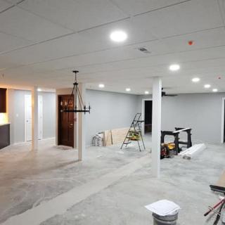 Unfinished basement undergoing renovation with construction materials and tools.