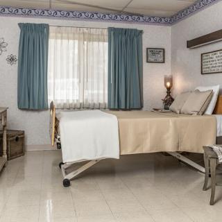 A hospital room with a single bed, curtains, and medical equipment.