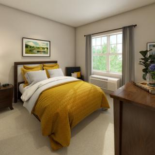 A cozy bedroom with yellow bedding and a large window.