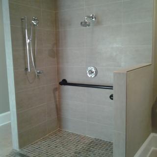 An accessible shower with grab bars and modern tile design.