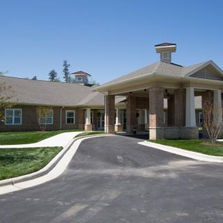 A building with a covered entrance and a driveway leading up to it.