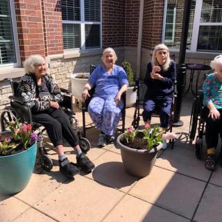 A group of seniors enjoying the outdoors on a sunny patio.