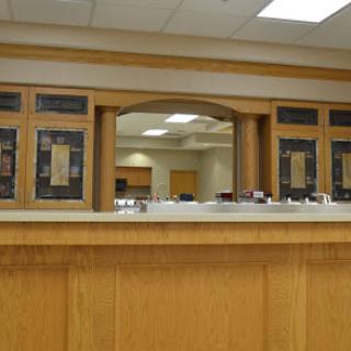 A modern reception area showcasing a wooden counter and a welcoming interior design.