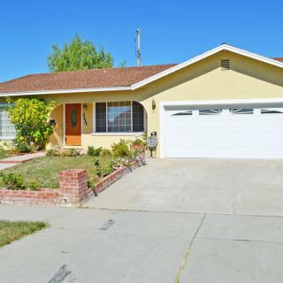 A suburban house with a garage and driveway on a clear day.