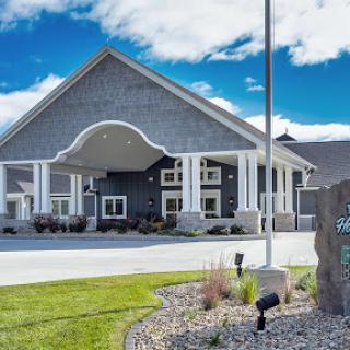 A modern hotel entrance featuring stylish architecture and well-maintained landscaping.