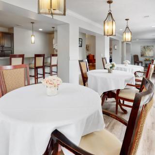 A well-decorated dining area with elegant lighting and neatly arranged tables and chairs.