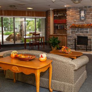A warm and inviting lobby area featuring comfortable seating, a fireplace, and decorative elements that enhance the cozy atmosphere.