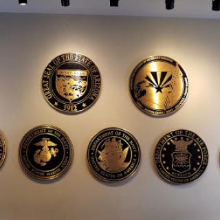 A display of various military seals mounted on a wall.