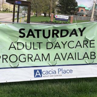 Outdoor banner advertising an available adult daycare program on Saturdays.