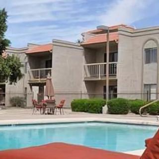 An apartment complex with an outdoor pool area and balconies.