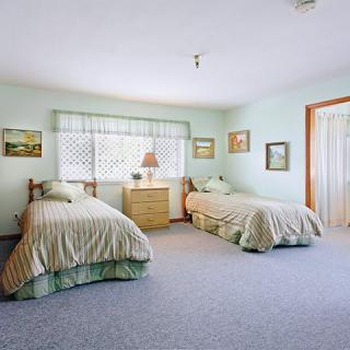 A cozy bedroom with twin beds and pastel decor.