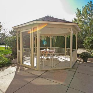 A charming wooden gazebo on a sunny patio in a garden setting.