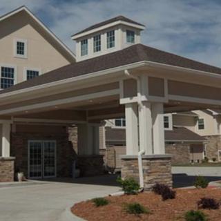 A modern residential building with a covered entrance and landscaped surroundings.