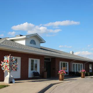A well-designed building surrounded by a clear blue sky and decorative flowers.