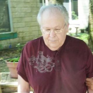 An older adult enjoying a walk outside in a garden setting.