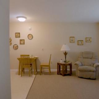 A cozy living room with a table, chairs, and decorative wall art.