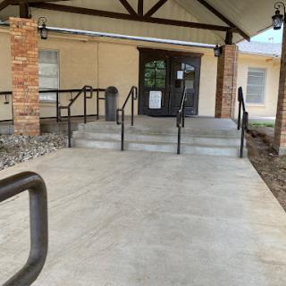 The entrance of a building featuring concrete steps and handrails.