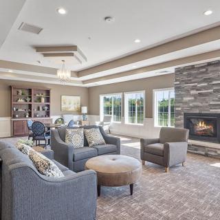 A cozy living room with comfortable seating, a fireplace, and large windows.