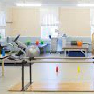 A rehabilitation room equipped with exercise machines and therapy tools.