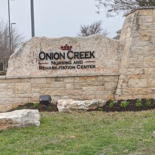 A stone entrance sign for Onion Creek Nursing and Rehabilitation Center.