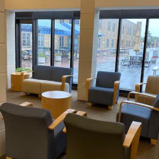 A cozy lounge area with comfortable seating and large windows bringing in natural light.