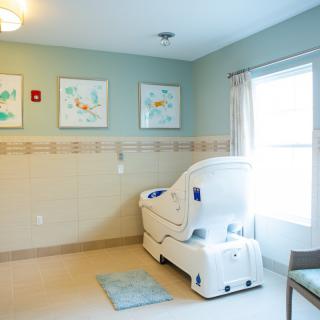 A modern healthcare bathroom featuring a walk-in tub with calming decor and natural light.