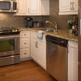 A modern kitchen with stainless steel appliances and white cabinetry.