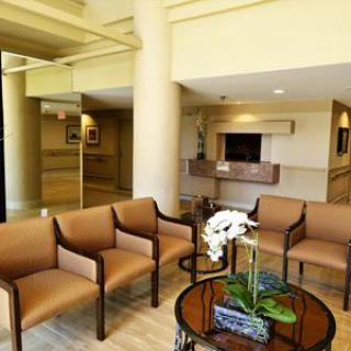 A contemporary waiting area featuring comfortable chairs and a decorative table with flowers.