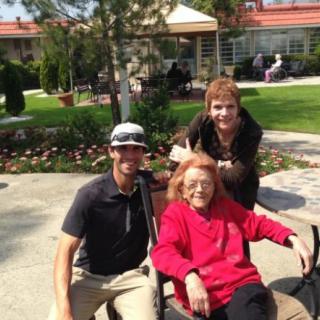 A group of three people enjoying a sunny day outdoors, with one person seated in a wheelchair.