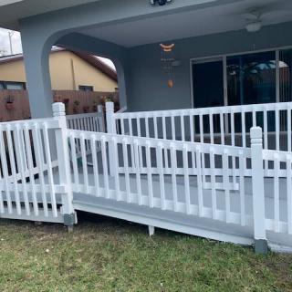 A white accessibility ramp leading to a patio area.