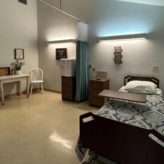 A well-organized hospital room with a bed and essential furniture.