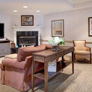 A cozy living room featuring a sofa, armchairs, a fireplace, and elegant decor.