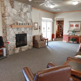 A cozy living room featuring a stone fireplace and comfortable seating area.