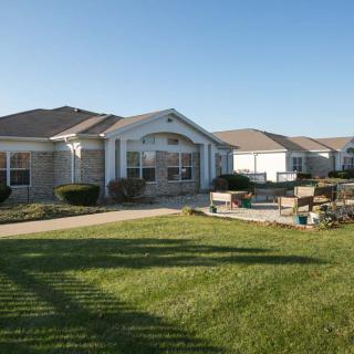 A suburban residential house with a well-maintained lawn and driveway.