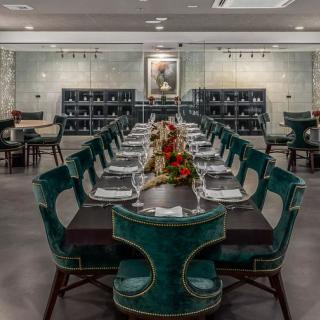 An elegant restaurant dining room with a long table and sophisticated decor.